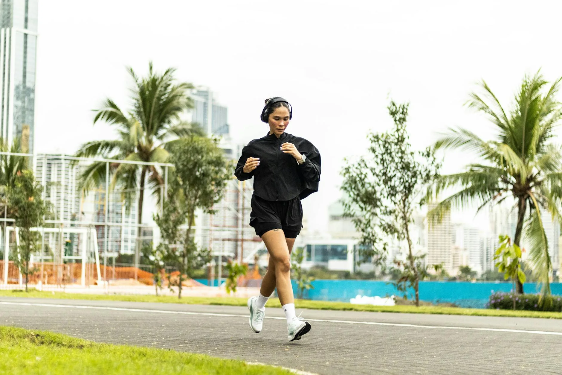 Runner with bone conduction headphones on a park path