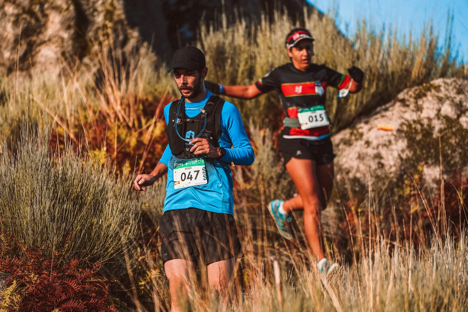 Trail runners wearing hydration vests during a race