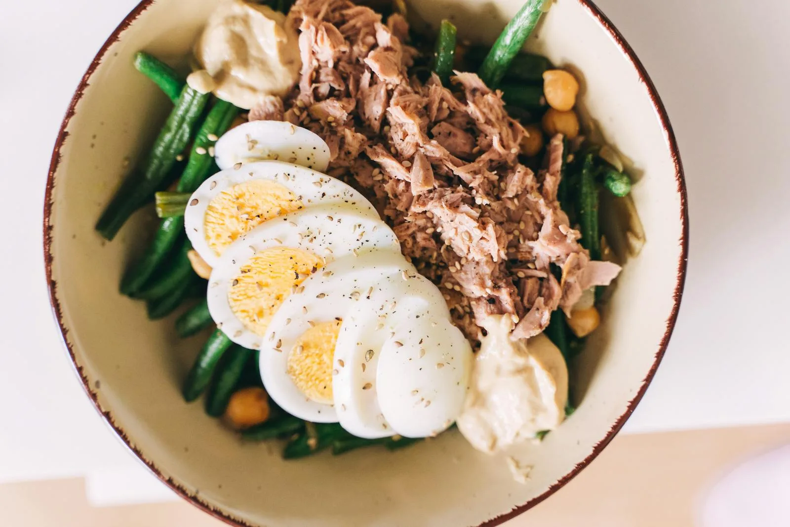 Healthy protein recovery bowl with eggs tuna chickpeas and vegetables