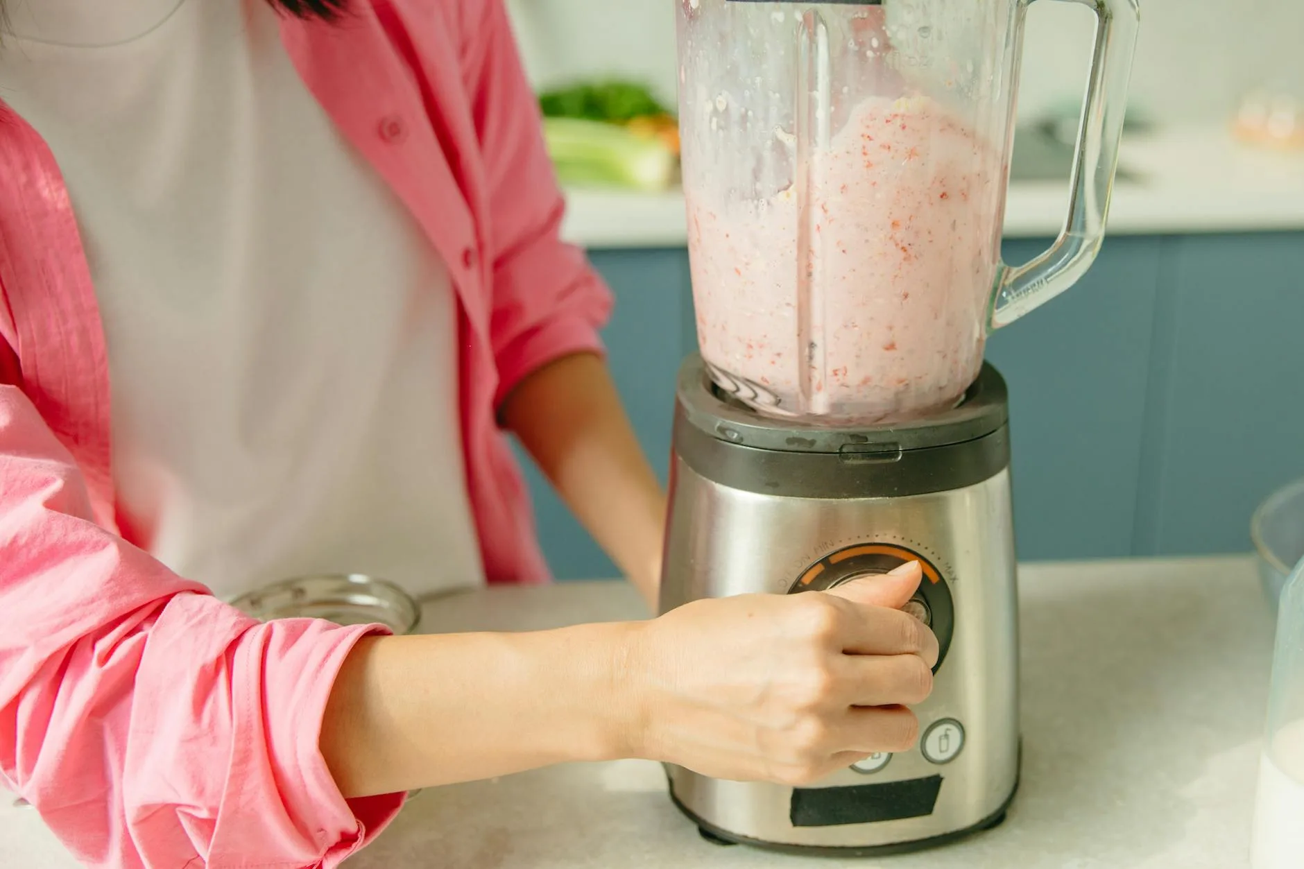 Protein shake being prepared with fruit in a blender
