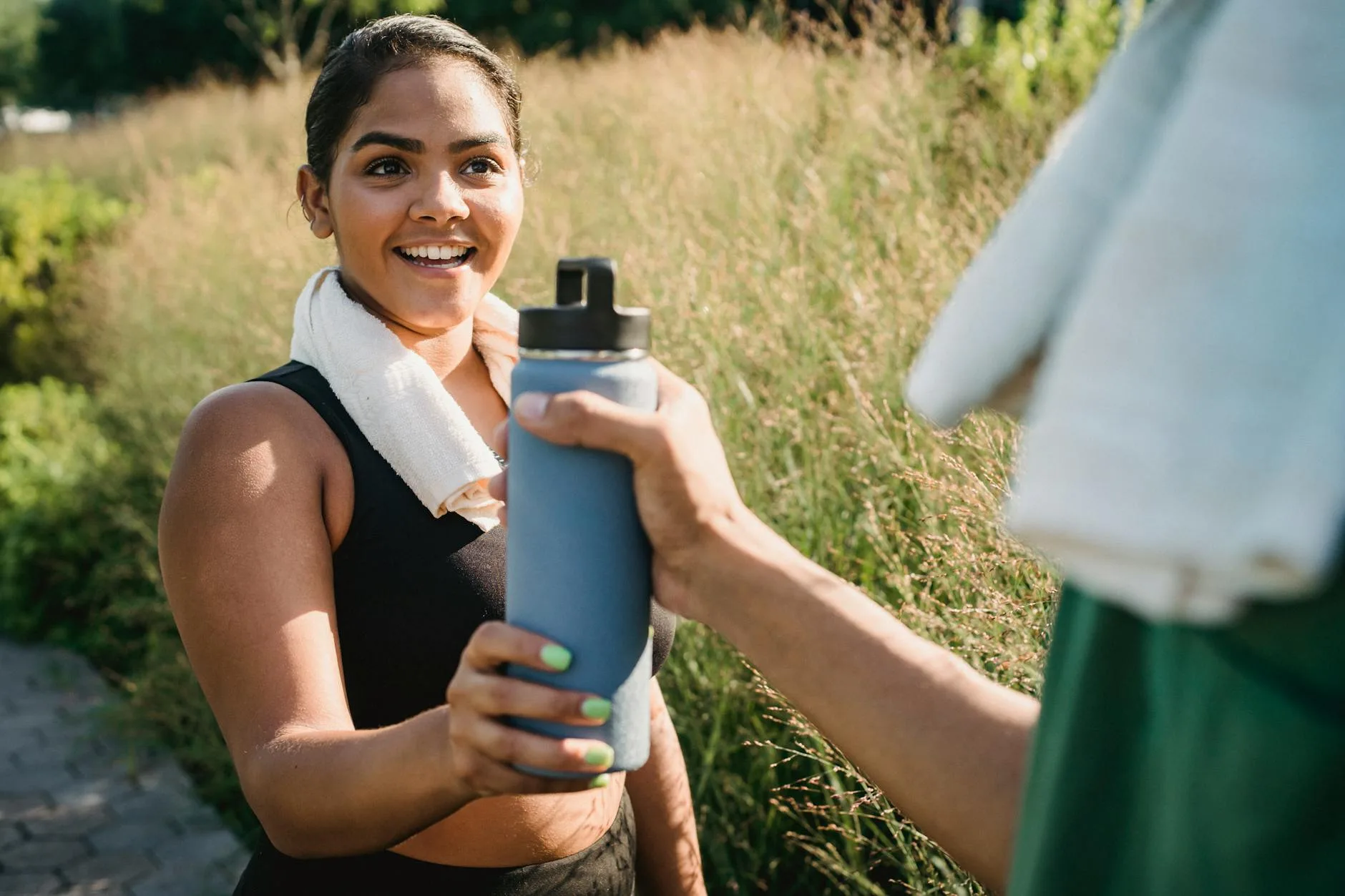 Runner taking a hydration break and drinking from a water bottle