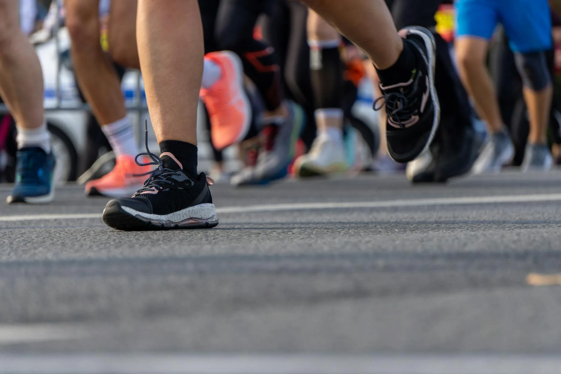 Close up of a runner's feet mid-stride on a road