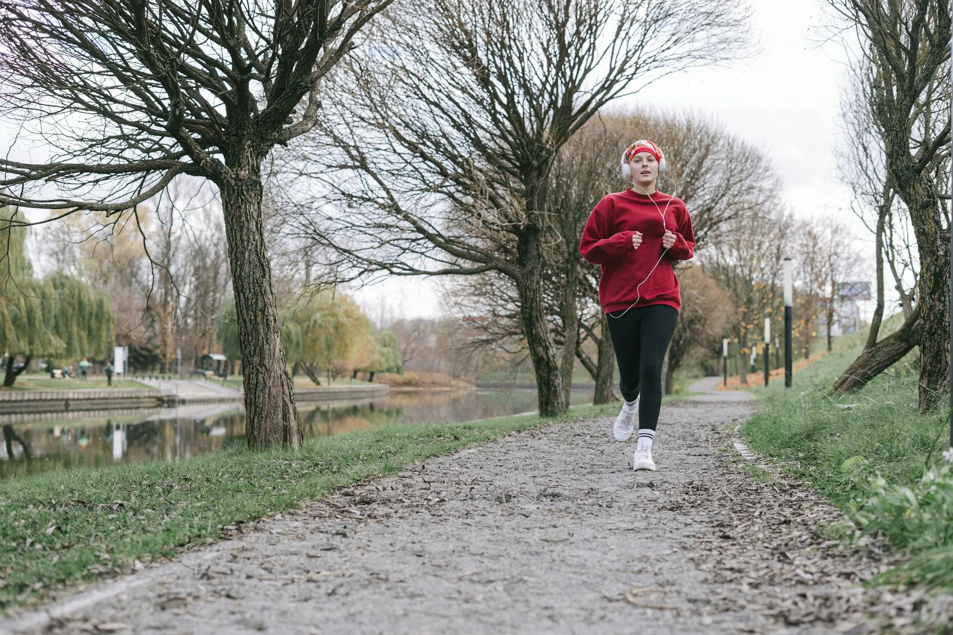 Runner jogging through a park on a cold autumn morning