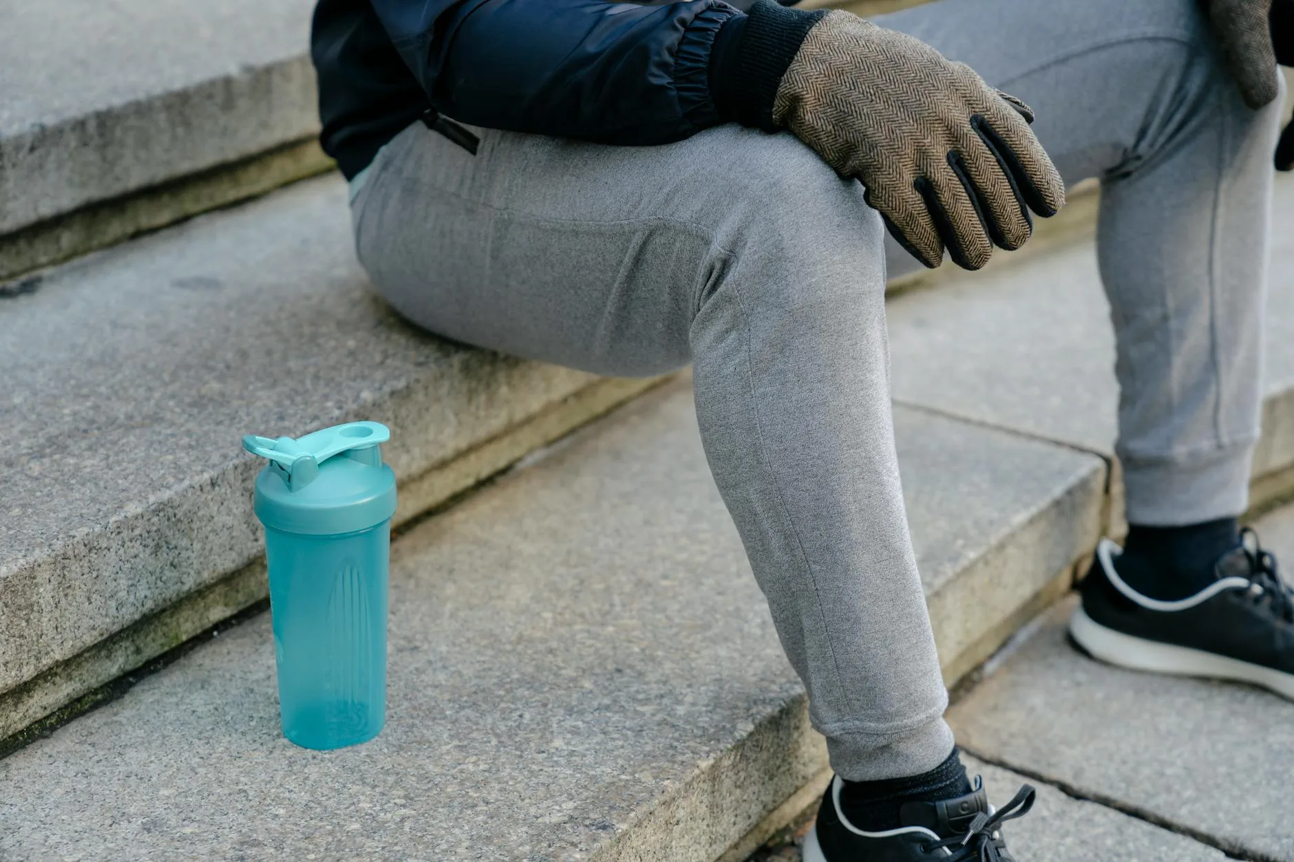 Runner taking a hydration break with a water bottle