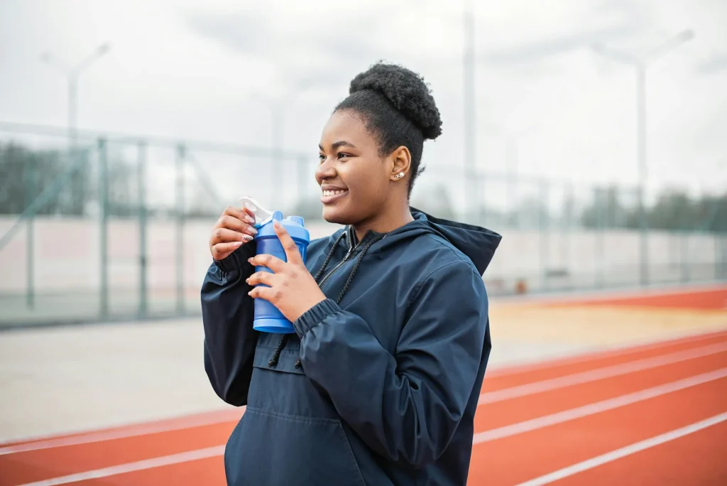 Runner carrying a handheld water bottle while jogging on a path