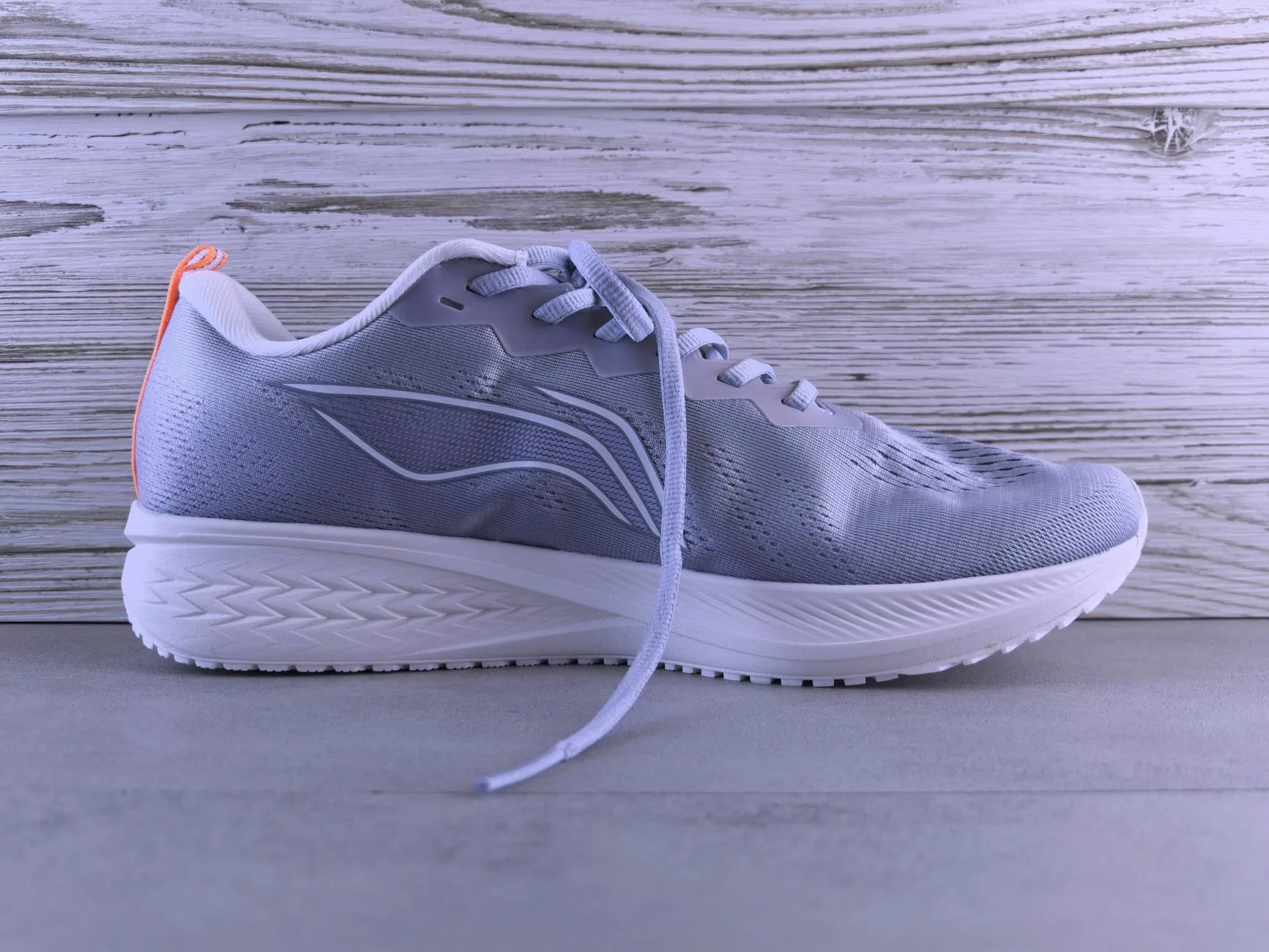 Running shoe showing outsole tread pattern and cushioning