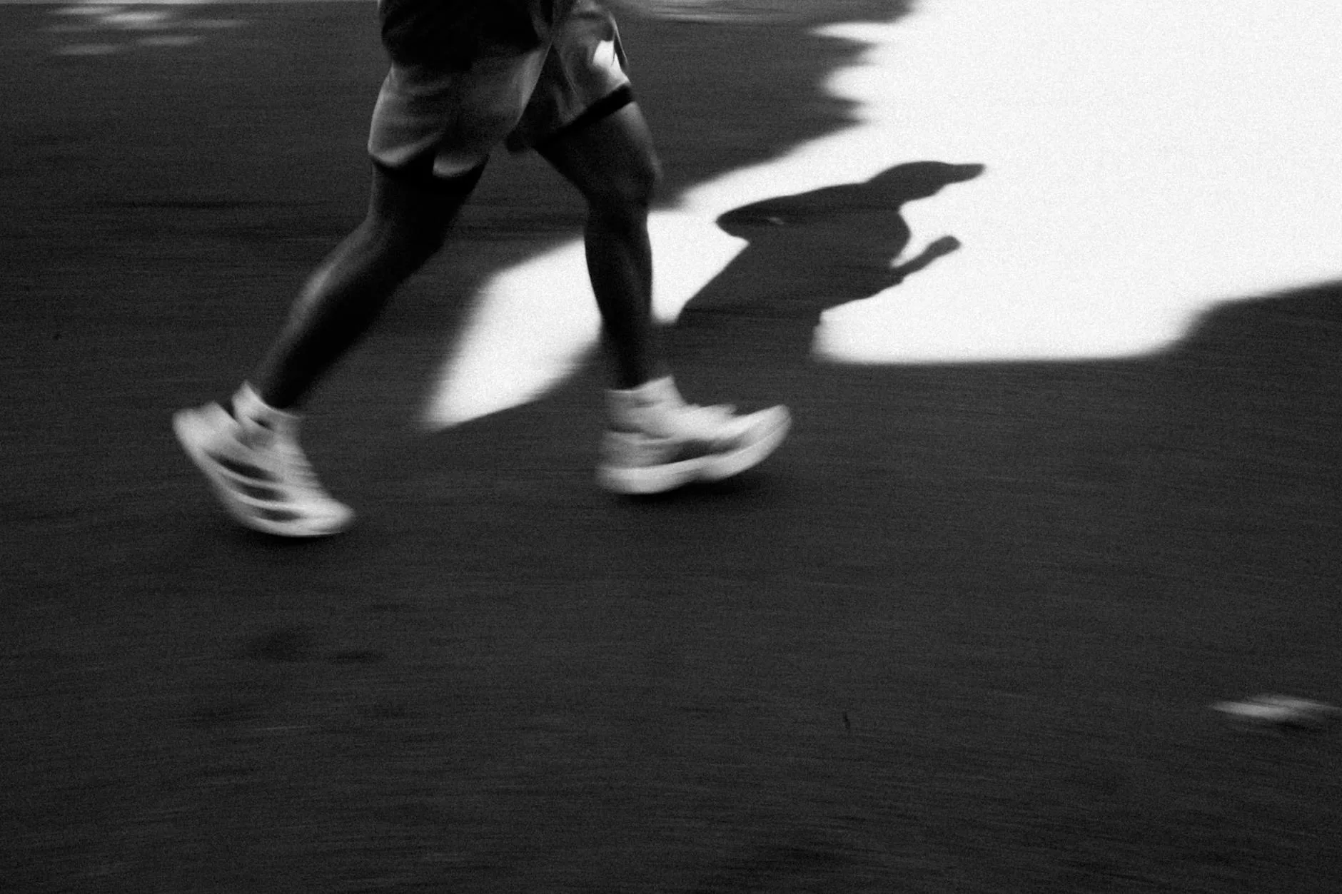 Runner mid-stride on a road surface in an urban setting