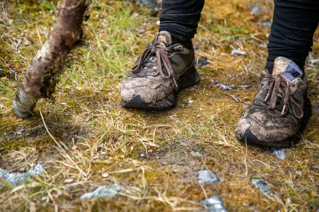 Runner in trail shoes on a muddy path through nature