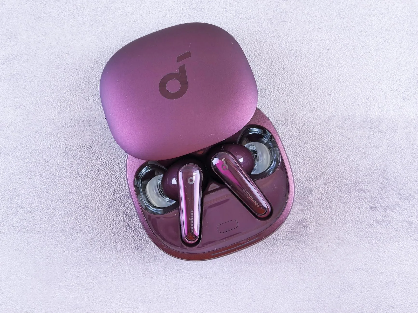 Wireless sport earbuds next to open charging case