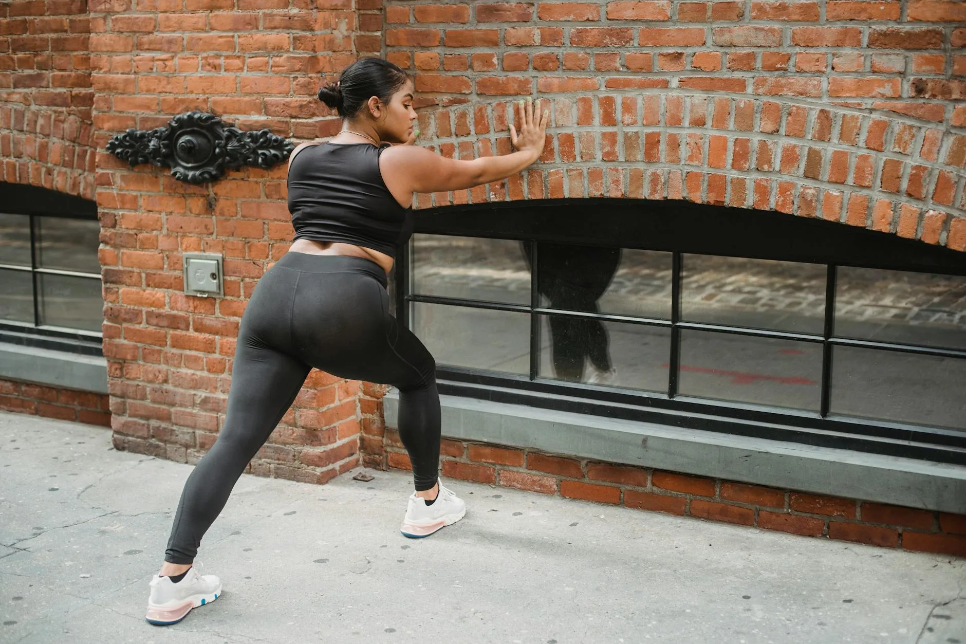 Runner doing a calf stretch against a wall after running