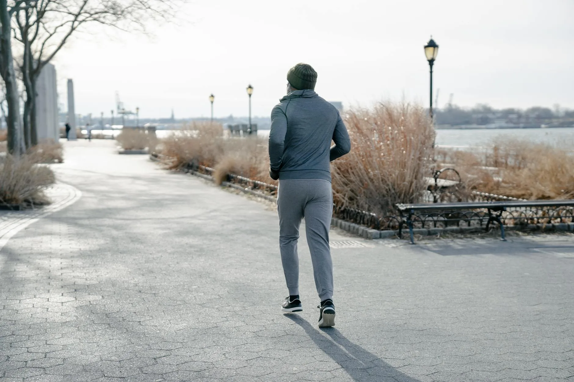Runner jogging at an easy pace through a park in the morning