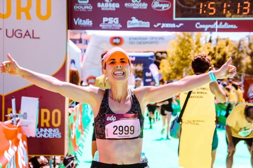 Runner crossing a finish line with arms raised