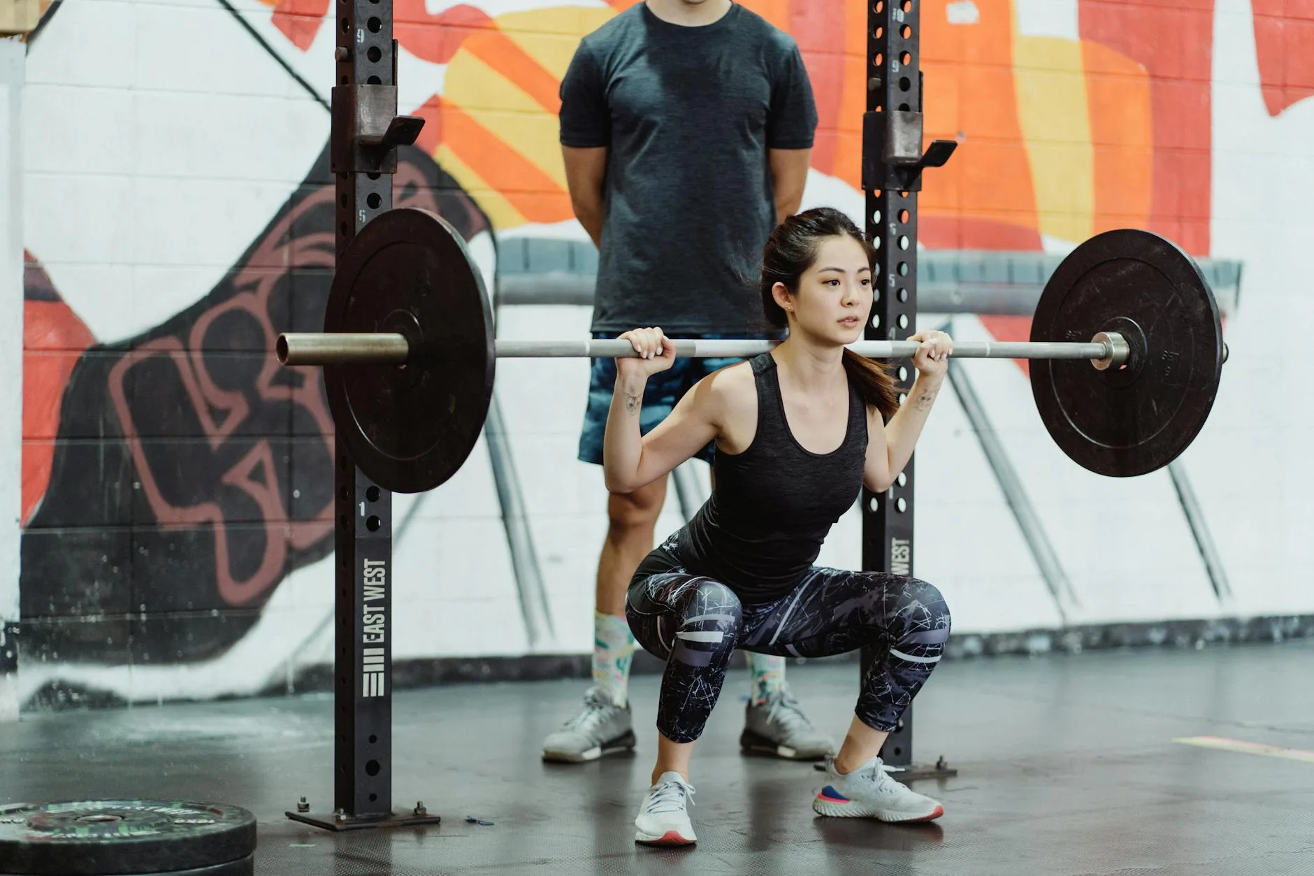 Person doing squats in a gym for running strength training