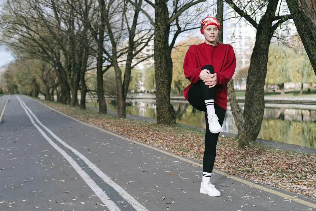 Runner stretching legs outdoors in a park before running