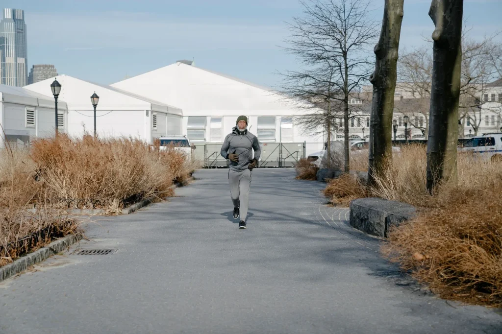 Runner warming up on a park path before training