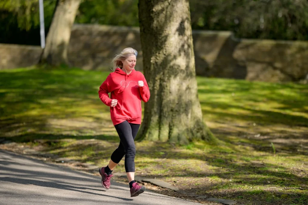 Older runner training on a park path for running after 40
