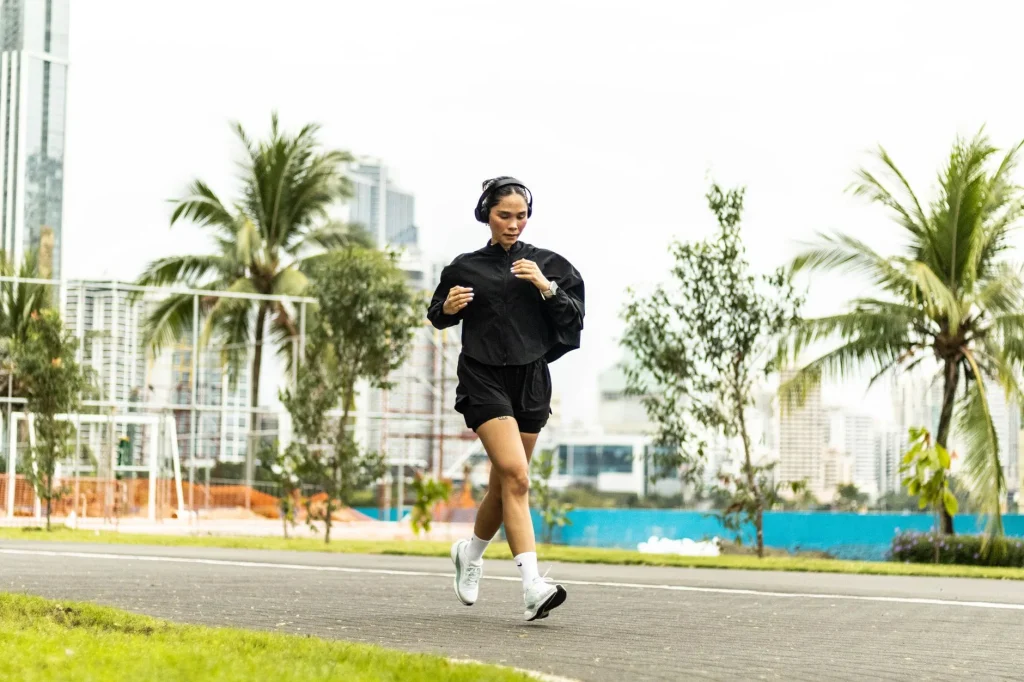 Runner checking a GPS watch before a long run with headphones