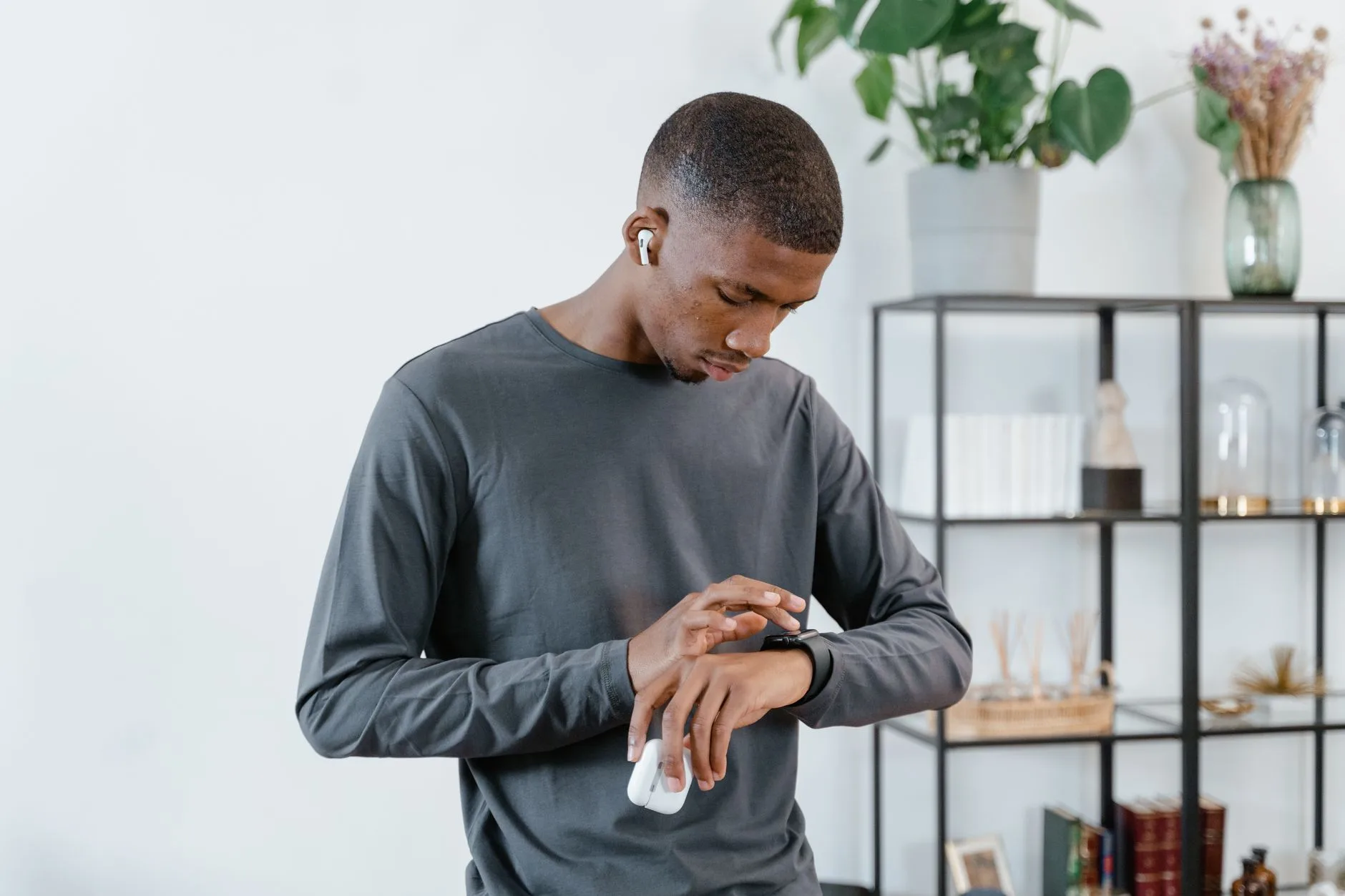 Runner using a smartwatch and wireless earbuds before a run