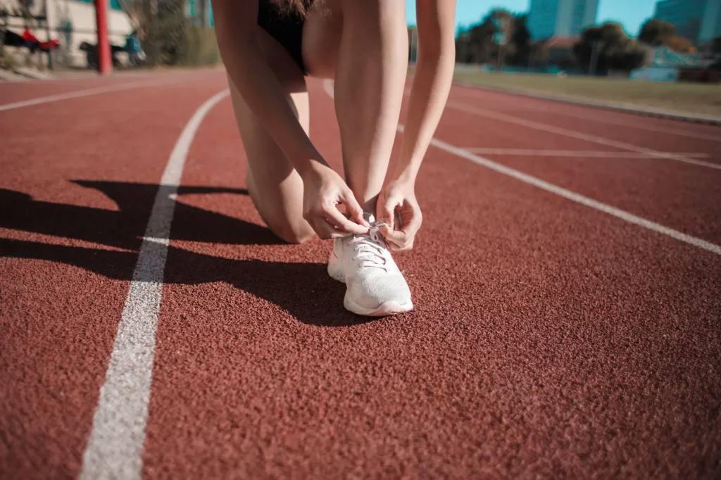 Runner preparing beside useful running accessories before an outdoor run